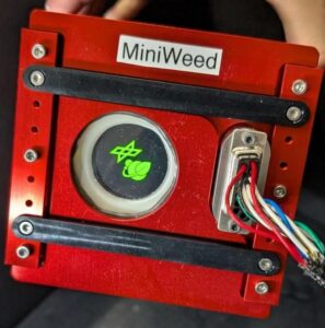 Square Miniweed device with DLR logo and wire connected.